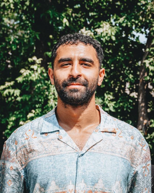Abdel outdoors in summer, looking at the camera